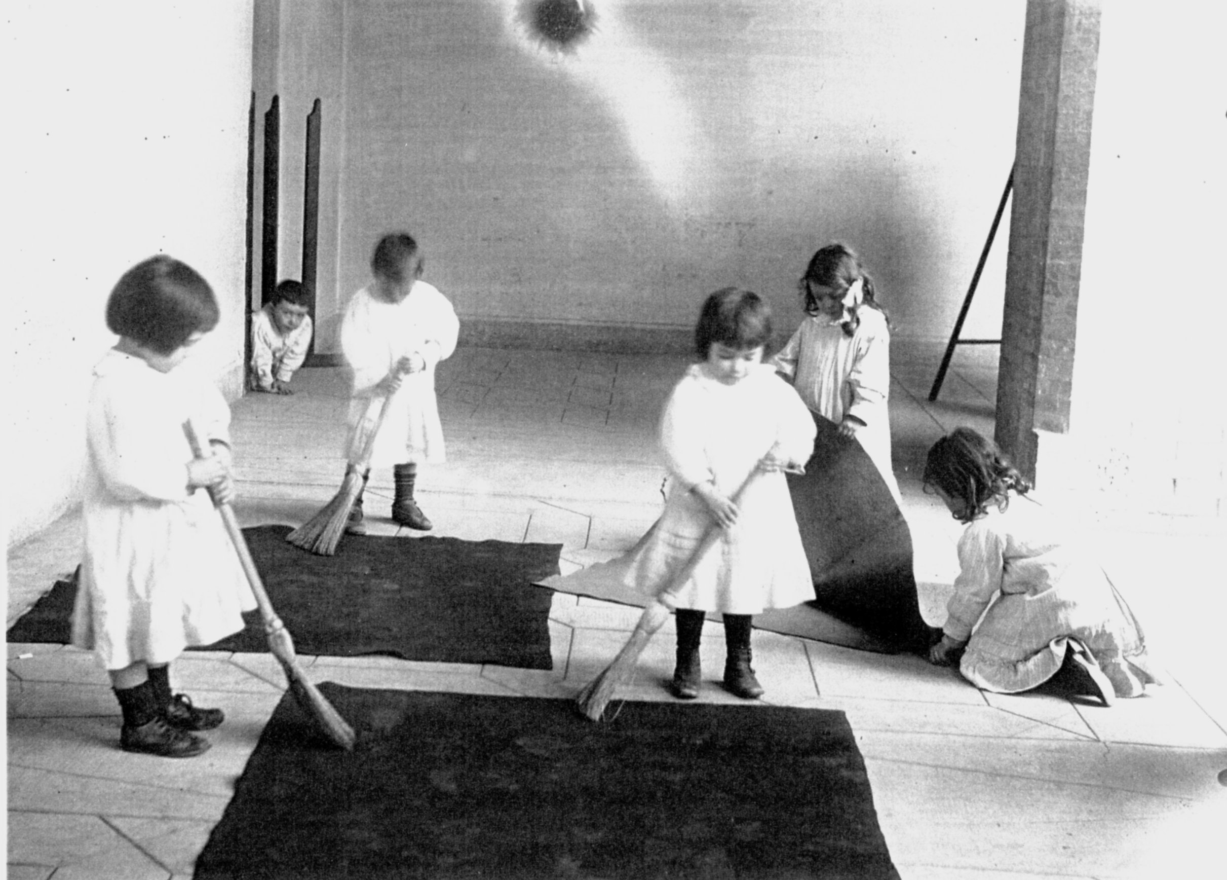 Via Giustiの子どもの家で、ほうきを使って掃除をする子どもたち