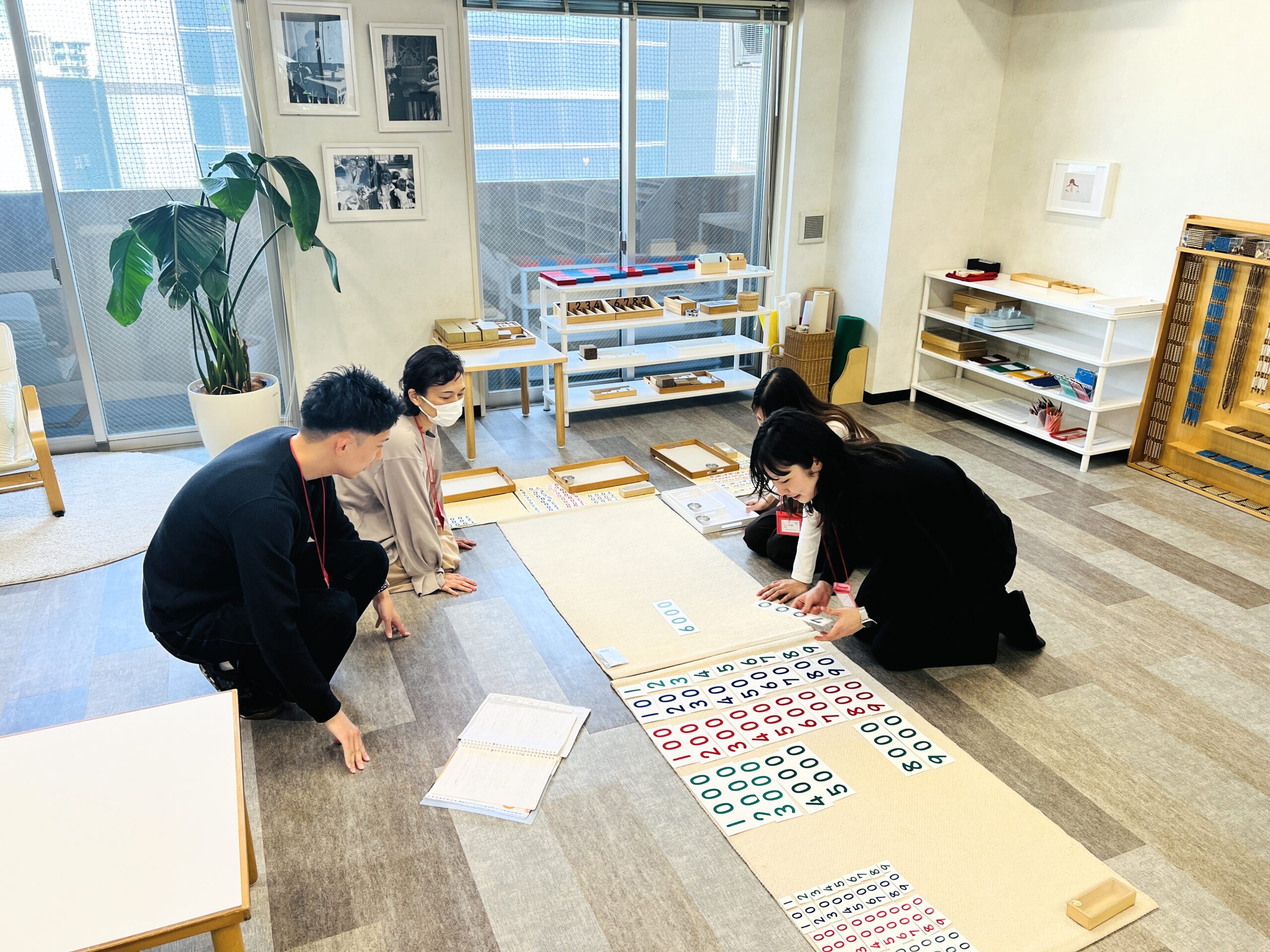 床にマットを広げ数のカードを使って学ぶ受講生たち
