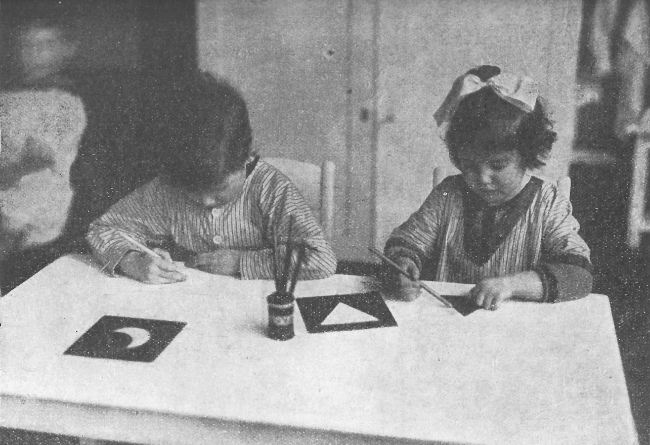 1920年代、メタルインセットを使って書くための手の動きを準備する子どもたち